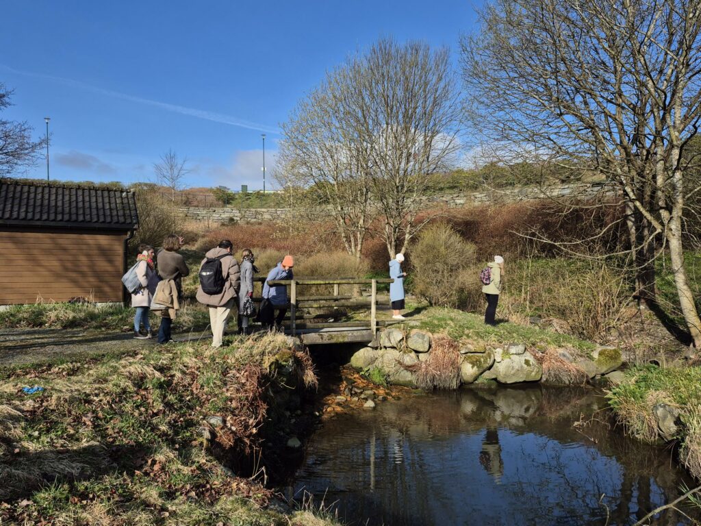 People on a bridge over a stormwater pond.